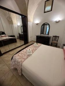 a bedroom with a large white bed and a mirror at Princess Mafalda house in Grottaglie