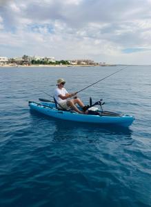 a man sitting in a blue kayak in the water at Wonder Land Hotel in Ras Sedr