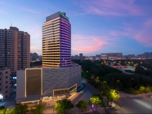 a tall building in a city at night at Holiday Inn Yiwu Center by IHG in Yiwu