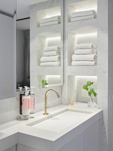 a white bathroom with a sink and a mirror at Numa Amsterdam Vondelpark in Amsterdam