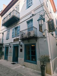 un edificio blanco con 2 balcones y una calle en Dias, en Nauplia