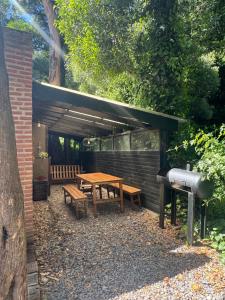 a picnic table and bench under awning at Ruca Tenglo in Mar del Plata +29 photos