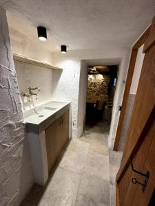 a bathroom with a sink and a hallway at Stone house Anja in Vrbnik