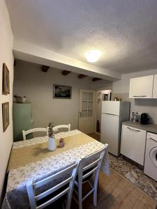 a kitchen with a table and a kitchen with a refrigerator at Stone house Anja in Vrbnik +12 photos