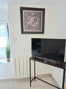 TV a/nebo společenská místnost v ubytování La longère du Moulin, logement T2 indépendant tout équipé avec cuisine, parking individuel avec portail, salon de jardin, belle grande chambre