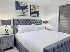 een slaapkamer met een groot bed en twee foto's aan de muur bij Westland Lodge in Brookmans Park