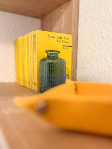 a book shelf with books and a jar on it at Eldorado Ferienwohnungen in Norddorf