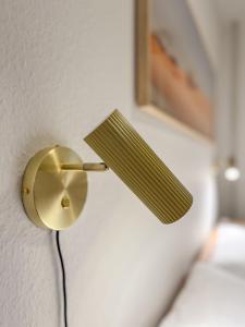 a gold lamp attached to a wall at Eldorado Ferienwohnungen in Norddorf