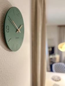 a green clock on the side of a wall at Eldorado Ferienwohnungen in Norddorf