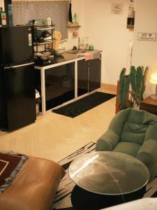 a living room with a green couch and a kitchen at TM Homestay Trung Tâm Phan Thiết 2 in Phan Thiet