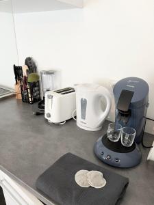 una encimera de cocina con licuadora y otros electrodomésticos en Studio moderne à 10 minutes de Paris avec jardin privé, en Romainville