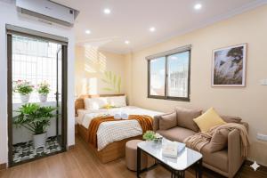 a living room with a bed and a couch at Aurelia Aparthotel Hanoi in Hanoi
