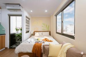 a bedroom with a bed and a couch at Aurelia Aparthotel Hanoi in Hanoi +45 photos