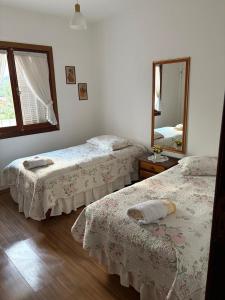 a bedroom with two beds and a mirror at Recanto da Vovó in Campos do Jordão