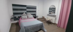 een slaapkamer met een bed met roze en witte kussens bij Cortijo El Pajaroto in Matanegra