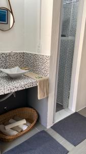 ein Bad mit einem Waschbecken und einem Korb mit Handtüchern in der Unterkunft Studio Beira Mar in Imbituba + 16 Fotos