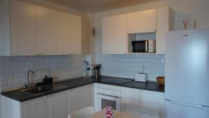 eine Küche mit weißen Schränken und schwarzen Arbeitsplatten in der Unterkunft Apartamento con vista frontal al mar in El Médano