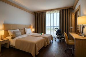 a hotel room with two beds and a desk at Domina Milano Fiera in Novate Milanese