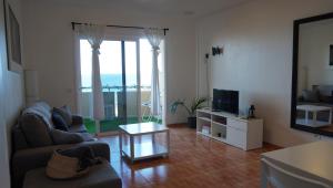 ein Wohnzimmer mit Sofa und Fernseher in der Unterkunft Apartamento con vista frontal al mar in El Médano