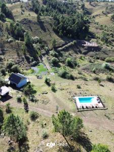 una vista aerea di una casa e di una piscina su una collina di Aire Escondido a Villa Berna