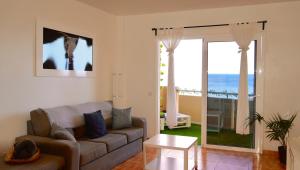 ein Wohnzimmer mit Couch und Blick aufs Meer in der Unterkunft Apartamento con vista frontal al mar in El Médano
