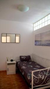 ein Schlafzimmer mit einem Bett und einem Fenster in der Unterkunft Apartamento con vista frontal al mar in El Médano + 16 Fotos