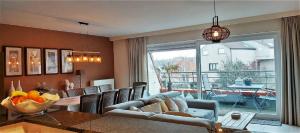 a living room with a table and a dining room at Botticelli in Koksijde