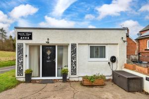 Finest Retreats - North View Annexe في Gilsland: منزل أبيض مع علامة على الباب