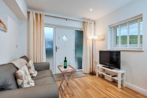 Finest Retreats - North View Annexe في Gilsland: غرفة معيشة مع أريكة وتلفزيون بشاشة مسطحة