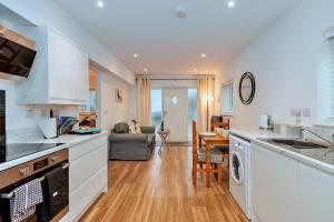 Finest Retreats - North View Annexe في Gilsland: مطبخ مع دواليب بيضاء وغرفة معيشة +7 صور