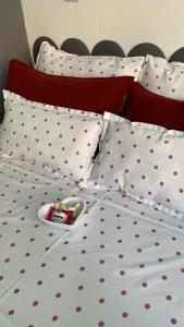 ein Bett mit gepunkteten Laken und einem Spielzeug darauf in der Unterkunft Studio Beira Mar in Imbituba