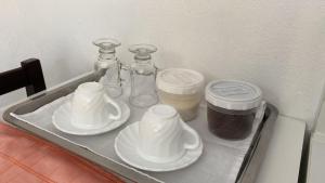 ein Regal im Kühlschrank mit Gläsern und Tellern in der Unterkunft Studio Beira Mar in Imbituba