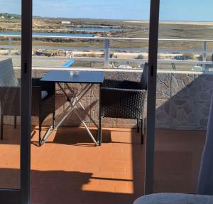 a table and chairs on a balcony with a view of the beach at Casa da Lena in Fuzeta +22 photos