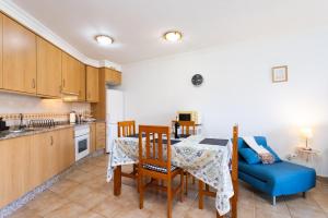 Una cocina y un comedor con mesa y sillas. en Apartamento Sotavento III S, en La Tejita