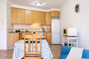 Una cocina con una mesa y un refrigerador blanco. en Apartamento Sotavento III S, en La Tejita 15 fotos más