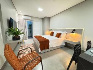 a bedroom with a bed and a table and chairs at Tc Lofts in Uberlândia