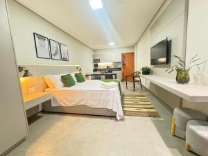 a large room with a bed and a kitchen at Tc Lofts in Uberlândia