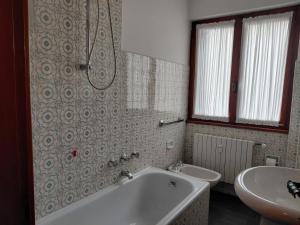 Bormio 5 villa في بورميو: حمام مع حوض استحمام ومغسلة