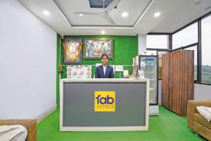 a woman standing behind a reception desk in a room at FabHotel Super Corridor 