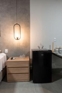 a room with a black refrigerator and a night stand at Tc Lofts in Uberlândia