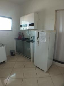 een keuken met een witte koelkast en een spoelbak bij Grussaí houses in São João da Barra