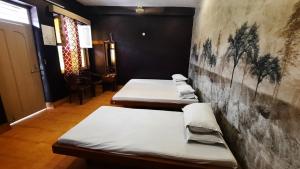two beds in a room with a wall at BALAN INTERNATIONAL lodging in Chennai
