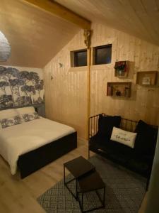 une chambre avec un lit et un canapé dans une pièce dans l'établissement La Belle Vie La, à Saintry-sur-Seine