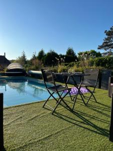 deux chaises et une table à côté d'une piscine dans l'établissement La Belle Vie La, à Saintry-sur-Seine