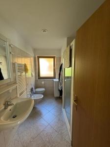 a bathroom with two sinks and two toilets at Appartamento Fontane in Panchia +16 photos