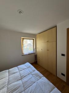a bedroom with a large bed and a window at Appartamento Fontane in Panchia