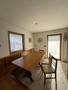 a dining room with a wooden table and chairs at Appartamento Fontane in Panchia