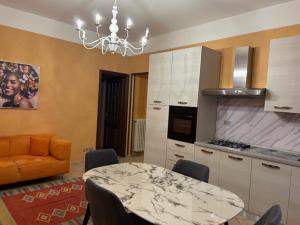 a kitchen with a dining room table and a chandelier at Residence Corona Grossa Balangero in Balangero