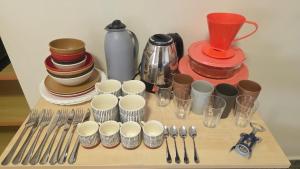 a table with utensils and cups and forks and spoons at Flat 8A confortável e completo próximo ao Hot Park e Pousada do Rio Quente in Rio Quente