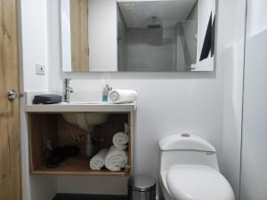 a bathroom with a sink and a toilet and a mirror at Nova Iorque Suites by Avia Suites in Bogotá